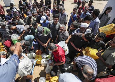 Palestinians carry jerry cans filled with water distributed by a water tanker-stock-foto
