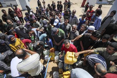 Palestinians carry jerry cans filled with water distributed by a water tanker-stock-foto