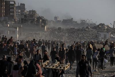 Palestinians carry food parcel, distributed by 'Gaza Humanitarian Relief Foundation' as people struggle with hunger during ongoing Israeli attacks in Gaza City-stock-foto