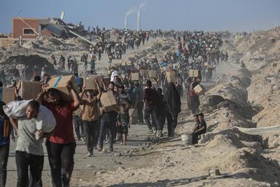 Palestinians carry food parcel, distributed by 'Gaza Humanitarian Relief Foundation' as people struggle with hunger during ongoing Israeli attacks in Gaza City-stock-foto