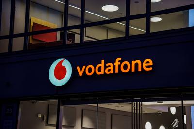 Das Markenlogo des Mobilfunkanbieters Vodafone in der M?nchner Innenstadt am Abend-stock-foto