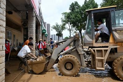 ZHAOQING, CHINA - JUNE 19: Residents use a front loader to transport debris and silt on June 19, 2025 in Huaiji County,-stock-foto
