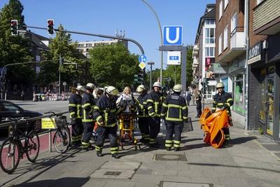 Rettungskraefte der Feuerwehr und Notaerzte am Unfallort im Einsatz beim Unfall U-Bahn Station Wandsbeker Chausse am 20.Juni 2925 in Hamburg. Eine blinde Frau ist beim Einfahren der U-Bahn vom Bahnsteig ins Gleisbett gestuerzt und von der Bahn erfasst worden und wird schwer verletzt Die Einsatzkr?fte gehen von einem tragischen Unfallgeschehen aus.Nach der Erstversorgung wurde die Schwerverletzte ins Krankenhaus gebracht. Hamburg Deutschland *** Rescue workers from the fire department and emergency doctors at the scene of the accident at the Wandsbeker Chausse underground station on June 20, 2925 in Hamburg A blind woman fell from the platform into the track bed when the underground train entered the station and was hit by the train and ser-stock-foto