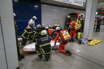 Rettungskraefte der Feuerwehr und Notaerzte am Unfallort im Einsatz beim Unfall U-Bahn Station Wandsbeker Chausse am 20.Juni 2925 in Hamburg. Eine blinde Frau ist beim Einfahren der U-Bahn vom Bahnsteig ins Gleisbett gestuerzt und von der Bahn erfasst worden und wird schwer verletzt Die Einsatzkr?fte gehen von einem tragischen Unfallgeschehen aus.Nach der Erstversorgung wurde die Schwerverletzte ins Krankenhaus gebracht. Hamburg Deutschland *** Rescue workers from the fire department and emergency doctors at the scene of the accident at the Wandsbeker Chausse underground station on June 20, 2925 in Hamburg A blind woman fell from the platform into the track bed when the underground train entered the station and was hit by the train and ser-stock-foto