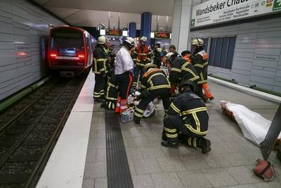 Rettungskraefte der Feuerwehr und Notaerzte am Unfallort im Einsatz beim Unfall U-Bahn Station Wandsbeker Chausse am 20.Juni 2925 in Hamburg. Eine blinde Frau ist beim Einfahren der U-Bahn vom Bahnsteig ins Gleisbett gestuerzt und von der Bahn erfasst worden und wird schwer verletzt Die Einsatzkr?fte gehen von einem tragischen Unfallgeschehen aus.Nach der Erstversorgung wurde die Schwerverletzte ins Krankenhaus gebracht. Hamburg Deutschland *** Rescue workers from the fire department and emergency doctors at the scene of the accident at the Wandsbeker Chausse underground station on June 20, 2925 in Hamburg A blind woman fell from the platform into the track bed when the underground train entered the station and was hit by the train and ser-stock-foto