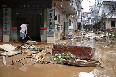ZHAOQING, CHINA - JUNE 19: A resident cleans debris and silt on the road on June 19, 2025 in Huaiji County, Zhaoqing Cit-stock-foto