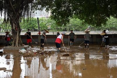 ZHAOQING, CHINA - JUNE 19: Staff members clean debris and silt on the road on June 19, 2025 in Huaiji County, Zhaoqing C-stock-foto