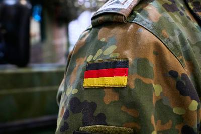 Augsburg, Bavaria, Germany - March 7, 2025: A Bundeswehr soldier in camouflage uniform with the German flag as a badge o-stock-foto