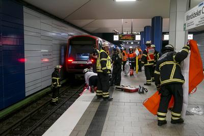 Rettungskraefte der Feuerwehr und Notaerzte am Unfallort im Einsatz beim Unfall U-Bahn Station Wandsbeker Chausse am 20.Juni 2925 in Hamburg. Eine blinde Frau ist beim Einfahren der U-Bahn vom Bahnsteig ins Gleisbett gestuerzt und von der Bahn erfasst worden und wird schwer verletzt Die Einsatzkr?fte gehen von einem tragischen Unfallgeschehen aus.Nach der Erstversorgung wurde die Schwerverletzte ins Krankenhaus gebracht. Hamburg Deutschland *** Rescue workers from the fire department and emergency doctors at the scene of the accident at the Wandsbeker Chausse underground station on June 20, 2925 in Hamburg A blind woman fell from the platform into the track bed when the underground train entered the station and was hit by the train and ser-stock-foto