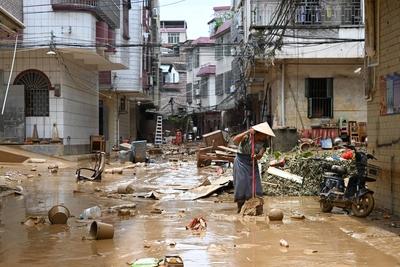 ZHAOQING, CHINA - JUNE 19: A resident cleans debris and silt on the road on June 19, 2025 in Huaiji County, Zhaoqing Cit-stock-foto