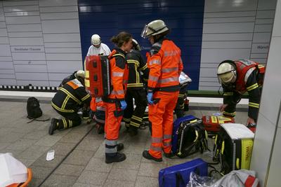 Rettungskraefte der Feuerwehr und Notaerzte am Unfallort im Einsatz beim Unfall U-Bahn Station Wandsbeker Chausse am 20.Juni 2925 in Hamburg. Eine blinde Frau ist beim Einfahren der U-Bahn vom Bahnsteig ins Gleisbett gestuerzt und von der Bahn erfasst worden und wird schwer verletzt Die Einsatzkr?fte gehen von einem tragischen Unfallgeschehen aus.Nach der Erstversorgung wurde die Schwerverletzte ins Krankenhaus gebracht. Hamburg Deutschland *** Rescue workers from the fire department and emergency doctors at the scene of the accident at the Wandsbeker Chausse underground station on June 20, 2925 in Hamburg A blind woman fell from the platform into the track bed when the underground train entered the station and was hit by the train and ser-stock-foto