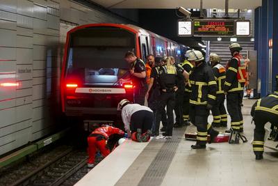 Rettungskraefte der Feuerwehr und Notaerzte am Unfallort im Einsatz beim Unfall U-Bahn Station Wandsbeker Chausse am 20.Juni 2925 in Hamburg. Eine blinde Frau ist beim Einfahren der U-Bahn vom Bahnsteig ins Gleisbett gestuerzt und von der Bahn erfasst worden und wird schwer verletzt Die Einsatzkr?fte gehen von einem tragischen Unfallgeschehen aus.Nach der Erstversorgung wurde die Schwerverletzte ins Krankenhaus gebracht. Hamburg Deutschland *** Rescue workers from the fire department and emergency doctors at the scene of the accident at the Wandsbeker Chausse underground station on June 20, 2925 in Hamburg A blind woman fell from the platform into the track bed when the underground train entered the station and was hit by the train and ser-stock-foto