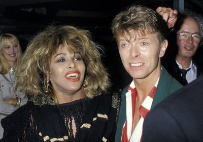 TINA TURNER & DAVID BOWIE London, England, Circa 1985 headshot portrait red lips lipstick red white stripe shirt green j-stock-foto