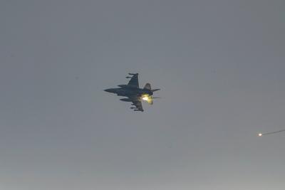 An Israeli fighter jet flies overhead as people rush towards an truck carrying humanitarian aid in western Jabalia-stock-foto