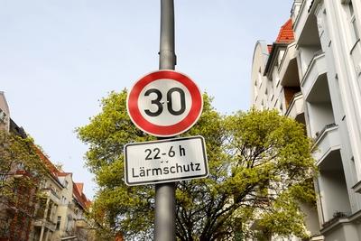 Verkehrsschild Tempo 30 mit dem Zusatzschild 22 6 h L?rmschutz vor einem gr?nen Baum Sicherheit im-stock-photo