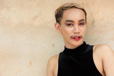 Beautiful Asian queer LGBT community supporter man with mustache wearing lipstick and jumpsuit Portrait of beautiful Asi-stock-photo