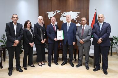 Palestinian Prime Minister, Mohammad Mustafa, receives the 2024 annual report of the Land Authority from the Chairman of the Land Authority, Alaa Tamimi-stock-foto