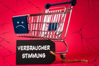 January 24, 2024: Shopping cart with a sad negative smiley, crumbling background and a label with inscription: Consumer-stock-foto