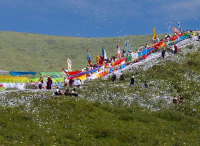 Wei Sang Fest in Tibet ABA, CHINA - JUNE 26: Locals dressed in traditional Tibetan attires throw prayer papers as they g-stock-photo