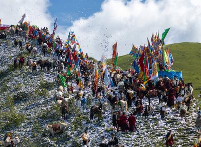 Wei Sang Fest in Tibet ABA, CHINA - JUNE 26: Locals dressed in traditional Tibetan attires throw prayer papers as they g-stock-photo