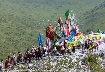 Wei Sang Fest in Tibet ABA, CHINA - JUNE 26: Locals dressed in traditional Tibetan attires throw prayer papers as they g-stock-photo