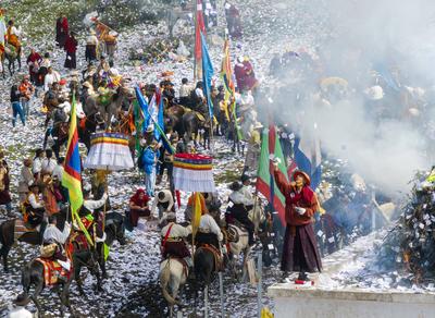 Wei Sang Fest in Tibet ABA, CHINA - JUNE 26: Locals dressed in traditional Tibetan attires throw prayer papers as they g-stock-photo