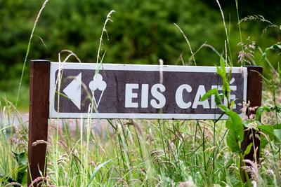 Schild mit Pfeil weist den Weg zu einem Eis-Cafe *** Shield with Arrow points the Path to a Ice Cafe 1083403682-stock-foto