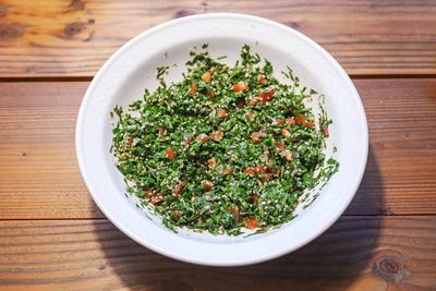 Taboule, Lebanese parsley salad with tomatoes, onions and mint in a white bowl on a rustic wooden table, seen from above-stock-foto