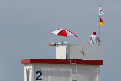 Ein Rettungsschwimmer sitzt am Mittwoch (14.08.2024) im Ostseebad Warnem?nde, ein Ortsteil der Hanse- und Universit?tsst-stock-foto