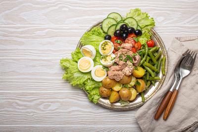 Nicoise salad with tuna, eggs, potatoes, green beans, and olives on a white table with copy space Delicious nicoise sala-stock-photo