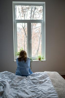 Einsame depressive Frau sitzt allein auf dem Bett zu Hause-stock-foto
