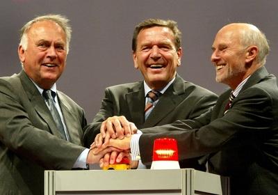 German Chancellor Gerhard Schroeder, center, push together with Saxony-Anhalt Governor Wolfgang Boehmer, left, and firm-stock-foto
