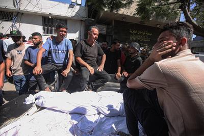 Relatives of Palestinians who lost their lives mourn in Al-Shifa Hospital after an Israeli bombing of a cafe shop-stock-photo