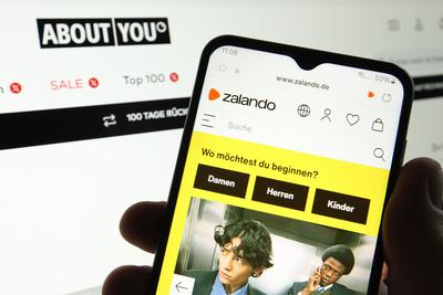 Auf einem Laptop wurde die Website vom Interneth?ndler About You ge?ffnet. Davor wurde auf einem Smartphone die Website-stock-foto