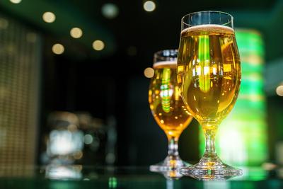 5 May 2025: Two glasses of beer on the counter of a bar, green lighting in the background *** Zwei Gl?ser mit Bier auf d-stock-foto