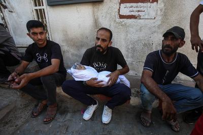 Relatives of Palestinians, who lost their loved ones following an Israeli airstrike on the Rimal Clinic-stock-foto