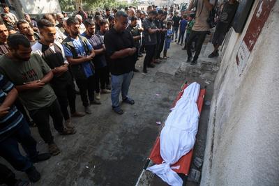 Relatives of Palestinians, who lost their loved ones following an Israeli airstrike on the Rimal Clinic-stock-foto