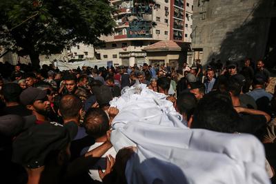 Relatives of Palestinians, who lost their loved ones following an Israeli airstrike on the Rimal Clinic-stock-foto