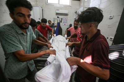 Relatives of Palestinians, who lost their loved ones following an Israeli airstrike on the Rimal Clinic-stock-foto