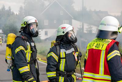 Feuerwehren r?cken zu Geb?udebrand aus ? Feuerwehr kam erst aus Waldbrandgebiet wieder zur?ck in die Heimat-stock-photo
