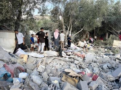 Palestinians assess the damage in the aftermath of an overnight Israeli strike that hit Nuseirat-stock-foto