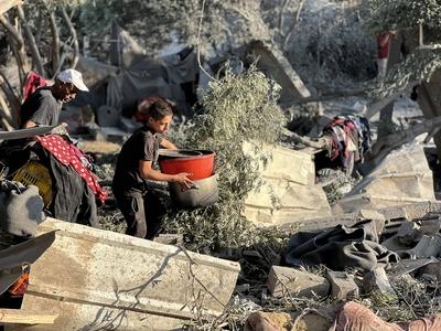 Palestinians assess the damage in the aftermath of an overnight Israeli strike that hit Nuseirat-stock-foto