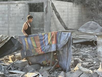 Palestinians assess the damage in the aftermath of an overnight Israeli strike that hit Nuseirat-stock-foto