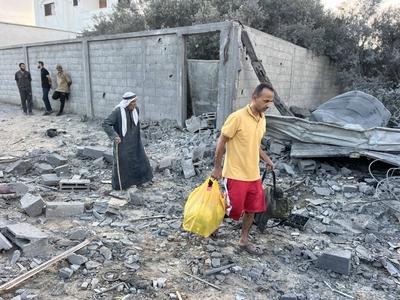 Palestinians assess the damage in the aftermath of an overnight Israeli strike that hit Nuseirat-stock-foto