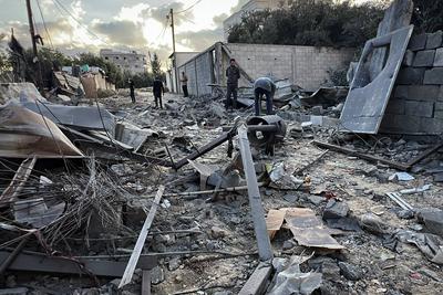 Palestinians assess the damage in the aftermath of an overnight Israeli strike that hit Nuseirat-stock-foto