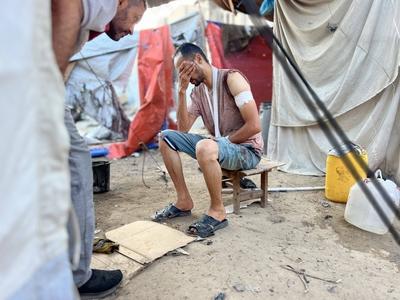 Palestinians assess the damage in the aftermath of an overnight Israeli strike that hit Nuseirat-stock-foto