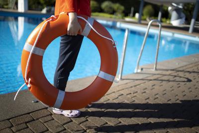 Bademeisterin mit Rettungsring im Schwimmbad. Bonn Deutschland *** Lifeguard with life belt in swimming pool Bonn Germa-stock-foto