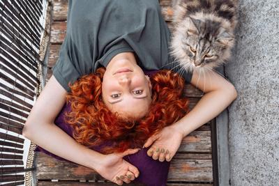 Portr?t rothaarige, lockige junge Frau, die sich auf einem Balkon oder einer Terrasse entspannt-stock-foto