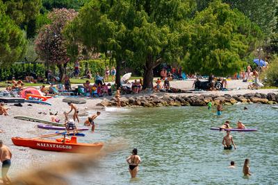 Torbole, Riva del Garda, Lake Garda, Italy - July 15, 2025: Tourists bustle along the shores of Lake Garda between Torbo-stock-foto