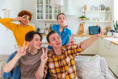 Cheers Funky Stimmung. Gl?ckliche Gruppe von Freunden machen Selfie. Mann macht Foto von Freunden auf Party. Gruppe von multirassischen jungen Menschen ein Foto auf dem Handy. Junge Menschen genie?en ihre Firma L?cheln haben Spa?.-stock-photo